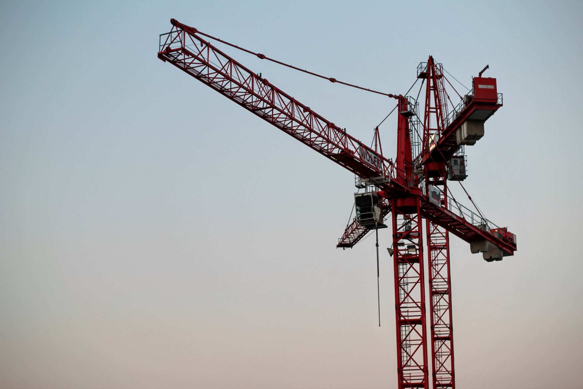 A photo of two red construction cranes